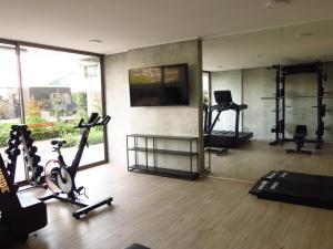 a gym with several treadmills and a flat screen tv at Dpto. Nuevo y Económico a 20’ del centro in Santiago