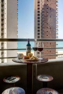 uma mesa com dois copos de vinho e um prato de comida em Flat Mar Azul - Beira Mar Fortaleza em Fortaleza