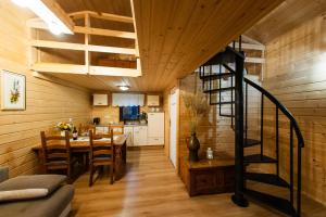 a kitchen and dining room with a spiral staircase in a house at Domek Na Morenie in Sieraków