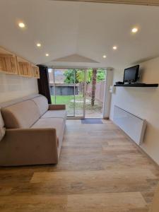 a living room with a couch and a tv at Cosy Chalet - Disney - Val d'Europe - Vallée Shopping - Parrot World in Villiers-sur-Morin