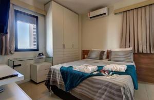um quarto com uma cama com duas toalhas em Flat Mar Azul - Beira Mar Fortaleza em Fortaleza