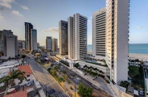 eine Luftansicht auf eine Stadt mit hohen Gebäuden und dem Meer in der Unterkunft Flat Mar Azul - Beira Mar Fortaleza in Fortaleza