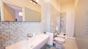 een badkamer met een wastafel, een toilet en een spiegel bij Affittacamere Zi Pasquale in Porto Recanati