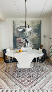 una sala da pranzo con tavolo e sedie bianchi di ApartmentInCopenhagen Apartment 1596 a Copenaghen