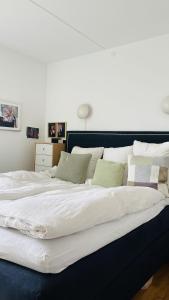 duże łóżko z białą pościelą i zielonymi poduszkami w obiekcie ApartmentInCopenhagen Apartment 1596 w Kopenhadze