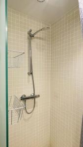 een douche in een badkamer met een betegelde muur bij ApartmentInCopenhagen Apartment 1596 in Kopenhagen