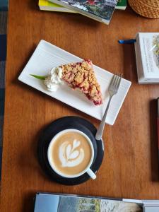a slice of pie on a plate with a cup of coffee at Yendegaia House in Porvenir +17 photos