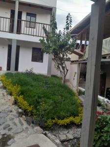 a house with a tree and flowers in front of it at Hotel Mahoma in El Cocuy