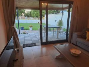 a living room with a door open to a patio at Addai Self Catering Brackenfell Durbanville area in Cape Town