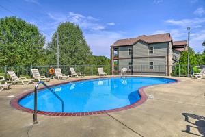 - une piscine avec des chaises et une maison dans l'établissement Spacious Branson West Retreat Pool and Golf Access!, à Branson West