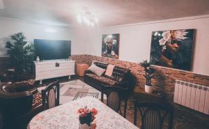 Una sala de estar con televisión, mesa y sillas. en La Cava de Leuvino Frias, en Presencio