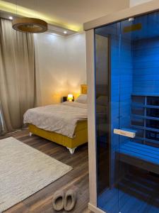 um quarto com uma cama e uma porta de vidro em Apartman Victoria em Novi Sad