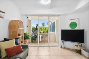 a living room with a couch and a television at The Lighthouse at Iluka Resort Apatments in Palm Beach