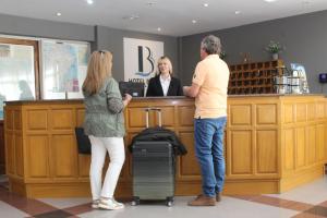 a man and a woman standing at a cash register at Hotel Bahía in Puerto San Julian