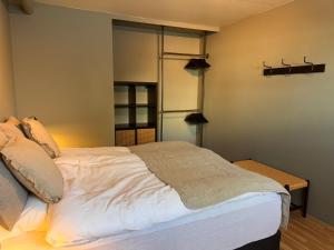 een slaapkamer met een groot bed met witte lakens bij AK-LUX102 in Akureyri