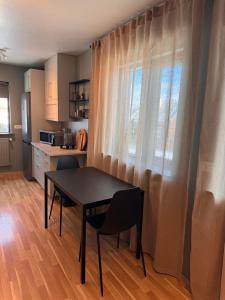 Una mesa y sillas en una cocina con ventana. en AK-LUX102, en Akureyri