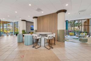 un vestíbulo con mesas y sillas en un edificio en Best Western Orlando Gateway Hotel en Orlando