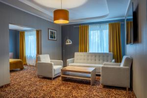a living room with a couch and two chairs and a table at Hotel Kuźnia Napoleońska in Teresin