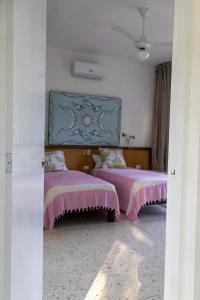 1 Schlafzimmer mit 2 Betten und rosafarbenen Bettdecken in der Unterkunft Papaya Casita - On an organic farm in Jamao al Norte