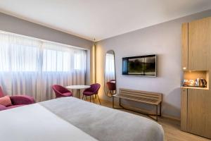 a hotel room with a bed and a table and chairs at Barceló Malaga in Málaga