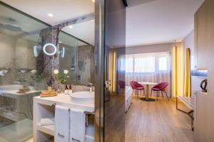 a bathroom with a sink and a table at Barceló Malaga in Málaga