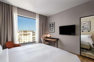 カサブランカにあるRadisson Hotel Casablanca Gauthier La Citadelleのベッドと大きな窓が備わるホテルルームです。