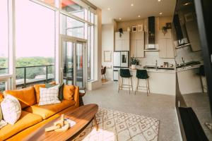 a living room with a couch and a kitchen at NEW Luxury 2BR Penthouse Apt In Central Halifax in Halifax