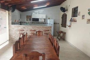 ein Raum mit einem langen Holztisch und Stühlen in der Unterkunft Casa na Martim de Sá in Caraguatatuba