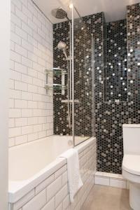 y baño con ducha, bañera y aseo. en Cosy 1-bedroom apartment - Putney High Street en Londres