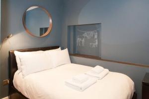 1 cama con espejo y 2 toallas plegables. en Cosy 1-bedroom apartment - Putney High Street en Londres
