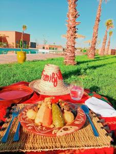 a picnic with a plate of food and a hat at Family Village Marrakech in Marrakesh