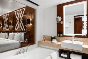 uma casa de banho com uma cama, um lavatório e um espelho. em Crowne Plaza Fiji Nadi Bay Resort & Spa, an IHG Hotel em Nadi