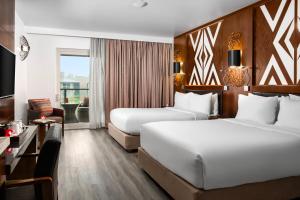 um quarto de hotel com duas camas e uma televisão em Crowne Plaza Fiji Nadi Bay Resort & Spa, an IHG Hotel em Nadi