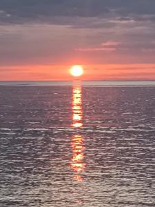 una puesta de sol sobre el océano con el sol reflejándose en el agua en Cloud9 rooms, en Fethiye