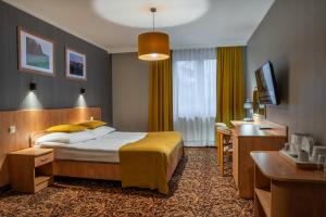 Cette chambre comprend un lit et un bureau. dans l'établissement Hotel Kuźnia Napoleońska, à Teresin