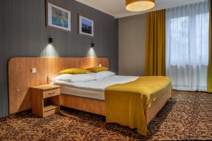 a bedroom with a bed with yellow pillows at Hotel Kuźnia Napoleońska in Teresin