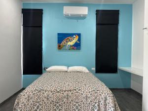 a bedroom with a bed with a blue wall at Casa Tortuga Valladolid in Valladolid