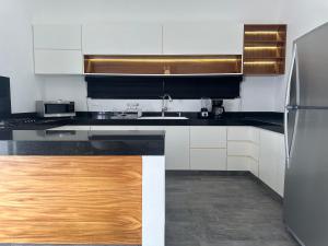 a kitchen with black and white counters and a refrigerator at Casa Tortuga Valladolid in Valladolid