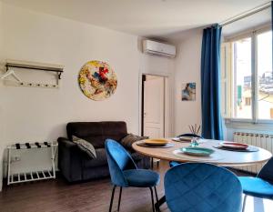 ein Wohnzimmer mit einem Tisch und blauen Stühlen in der Unterkunft Ariento House by 360Rentals in Florenz