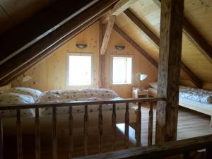 a attic room with a bed and two windows at Chalupa Granát in Kořenov