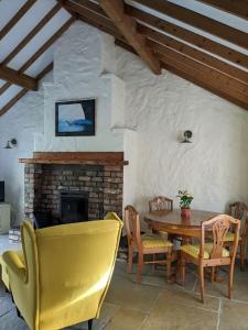 a living room with a table and chairs and a fireplace at Molly's Cottage in Larne +20 photos