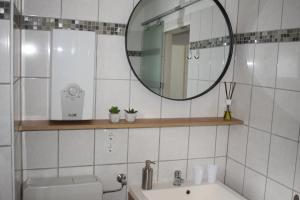 La salle de bains est pourvue d'un miroir et d'un lavabo. dans l'établissement Alpha Alpin Apartment, à Zell am See