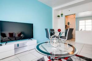 a living room with a glass table and a tv at Amazing apartment in Miami Beach in Miami Beach