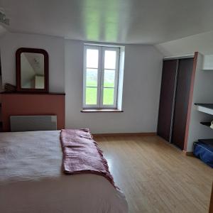 a bedroom with a large bed and a mirror at Maison de charme en campagne, 5 min du haras du pin in Nonant-le-Pin
