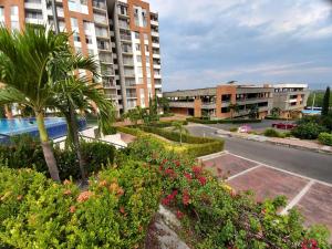 a view of a building with plants and flowers at Reserva del Peñón Girardot - Apartamento Vacacional Familiar Confort La Esmeralda in Girardot