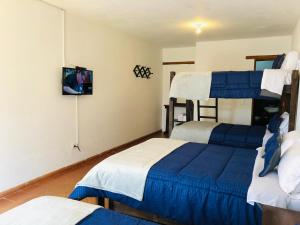 a bedroom with two bunk beds and a tv at HOTEL RUTA 40 VILLA DE LEYVA in Villa de Leyva