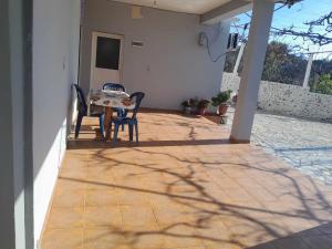 a patio with two chairs and a table on a house at Kalemi Sunrise Studios in Borsh