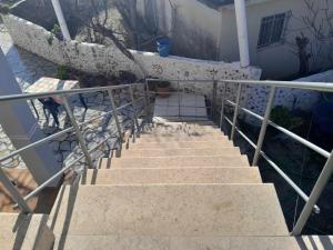 a staircase leading up to a house with a stair railing at Kalemi Sunrise Studios in Borsh
