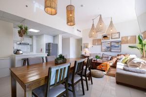 eine Küche und ein Wohnzimmer mit einem Holztisch und Stühlen in der Unterkunft Stylish 3 bedrooms Boho-Style Home in Dubai