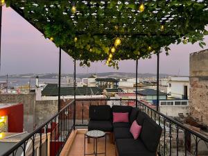 a balcony with a couch on top of a building at House in old Medina for 10 guests in Tangier